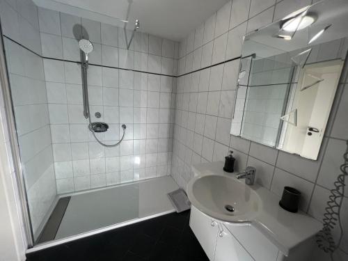 文登Hotel Restaurant Zum Landmann的白色的浴室设有水槽和淋浴。