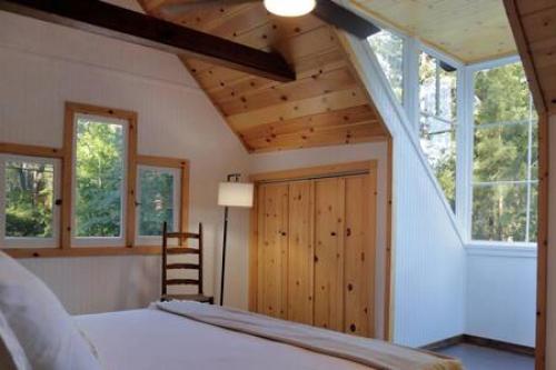 爱德怀Hobbit House - Charming In Town的一间卧室设有床,还有一些窗户和梯子