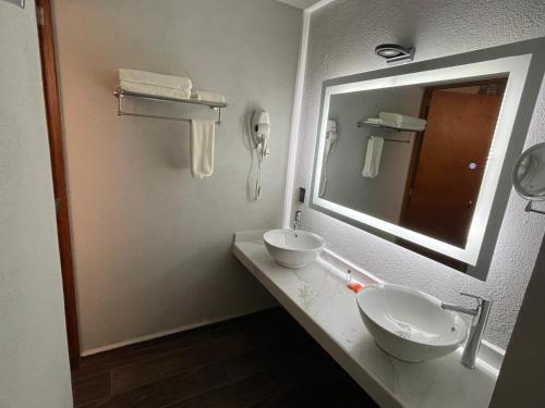 塔马索波Hotel Casa María Tamasopo的一间带两个盥洗盆和大镜子的浴室