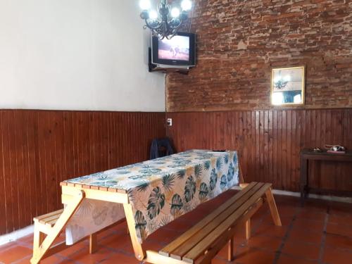 罗萨里奥Alojamiento hostel Lodeolga "La Florida"的带电视的客房内的木凳