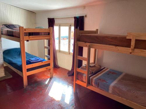 罗萨里奥Alojamiento hostel Lodeolga "La Florida"的客房设有三张双层床和一扇窗户。