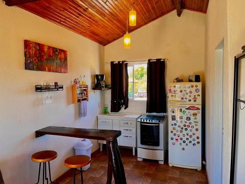 戈亚斯州上帕莱索Chalé Uyuni的带冰箱和桌子的厨房