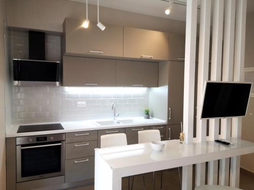 科莫蒂尼Porcelani studio Komotini的一间带白色台面的厨房和一台电视
