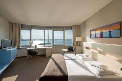 不来梅港赛欧城市大西洋酒店的酒店客房设有一张床、一张书桌和窗户。