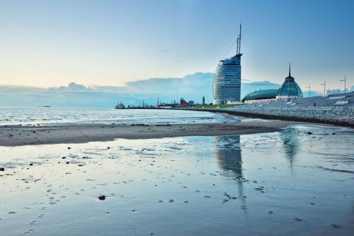 不来梅港赛欧城市大西洋酒店的一座拥有建筑背景和海洋的海滩