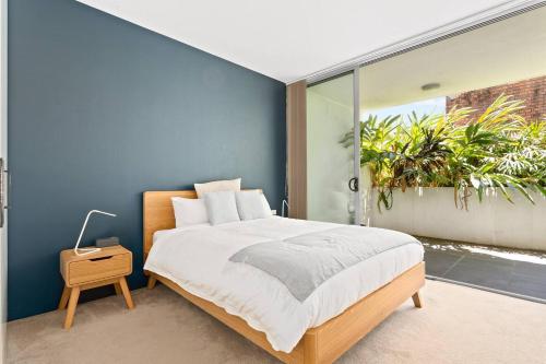 悉尼Sunshine Pacific - A Spacious Boutique Stay的一间卧室设有一张大床和蓝色的墙壁