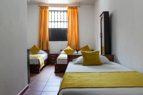 希龙Hotel Colonial San Felipe的酒店客房设有两张床和窗户。