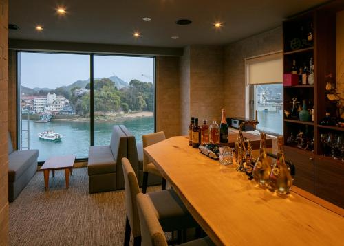 尾道市Sakura Hotel Onomichi Ekimae的客房设有长木桌,享有河景