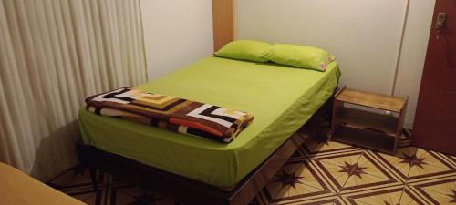 万查科Travelershouse Casa Hospedaje的一间小卧室,配有一张带绿色床单的床