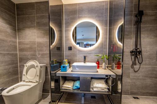 昆明龚禧里·禧见酒店(昆明东风东路大树营地铁站店)的浴室配有盥洗盆、卫生间和浴缸。