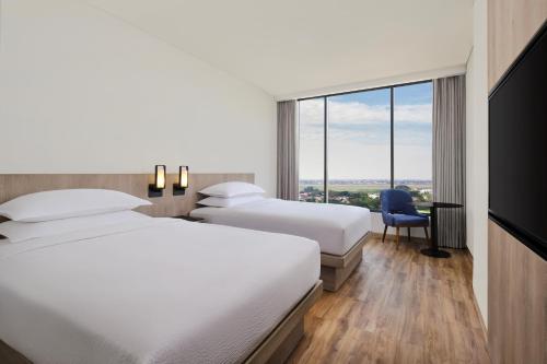 当格浪Fairfield by Marriott Jakarta Soekarno-Hatta Airport的酒店客房设有两张床和窗户。