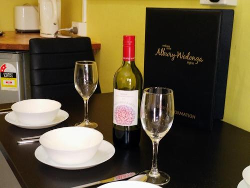 奥尔伯里奥尔伯里中心汽车旅馆的桌子上放有一瓶葡萄酒和两杯酒