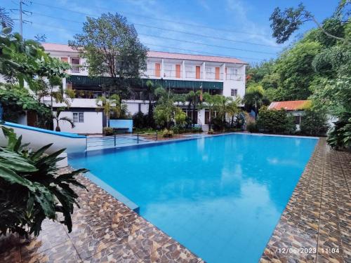 纳苏格布AS Ilaya Resort and Event Place powered by Cocotel的大楼前的大型蓝色游泳池