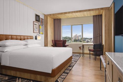 名古屋Four Points by Sheraton Batam的配有一张床和一张书桌的酒店客房