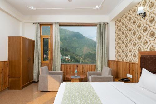 达兰萨拉Vella Marina Group of hotels Mcleodgunj的酒店客房设有一张床和一个大窗户