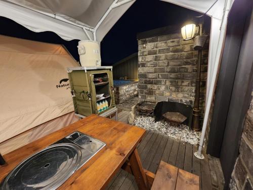 仁川市Hotel 498的帐篷配有木桌和燃木火炉