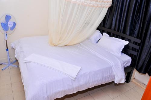 内罗毕Milany Homes - NEAR JKIA AIRPORT的一间卧室配有一张带天蓬的白色床