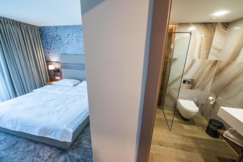 珀尔蒂尼什La MOONte的一间卧室配有一张床,浴室设有卫生间
