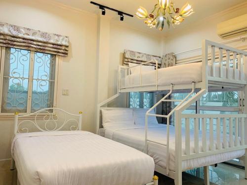 七岩พูลวิลล่าชะอำ Amazia Pool Villa的一间卧室设有两张双层床和吊灯。