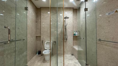 丹绒道光Cozy Straits Quay Seafront Suite的一间带玻璃淋浴和卫生间的浴室
