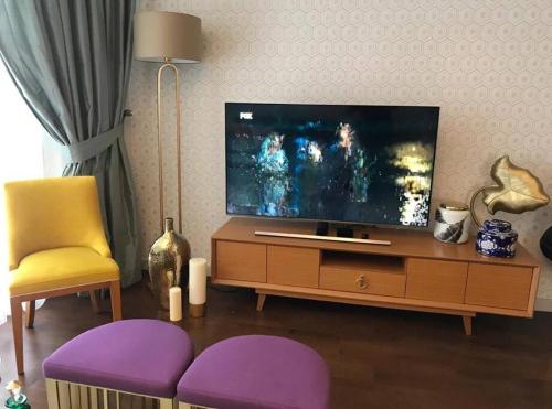 伊斯坦布尔luxury apartments in Istanbul的客厅配有平面电视和紫色椅子