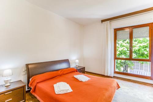 马里纳迪马萨Casa Arno 500m from beach的一间卧室配有橙色的床和窗户。