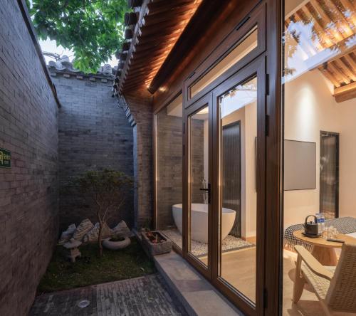 北京Beijing wu tong的浴室设有滑动玻璃门和浴缸。