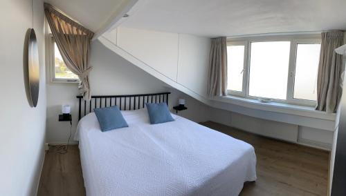 斯霍尔sunshine的一间卧室配有白色的床和2个蓝色枕头
