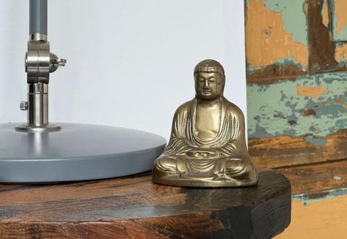 BlackwaterThe Wimberry的铜佛像坐在水槽旁边的桌子上
