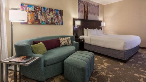 波特兰Courtyard by Marriott Portland City Center的酒店客房配有床、沙发和椅子