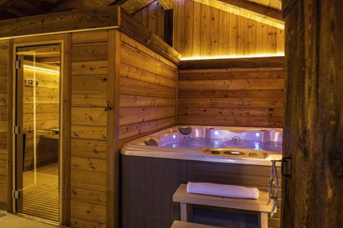 夏蒙尼-勃朗峰Chalet Black Wood的木制浴室内的按摩浴缸