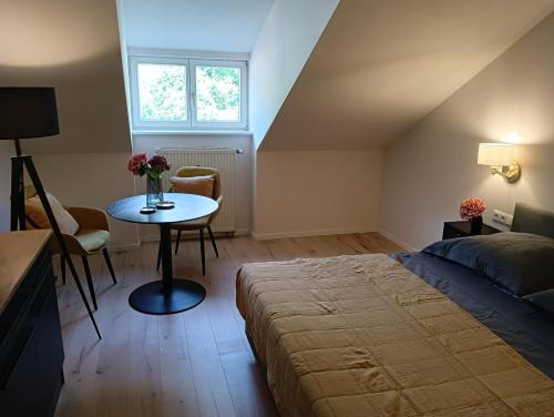 基姆高地区阿绍Appartment Schloss-Zeit的一间卧室配有一张床和一张鲜花桌子