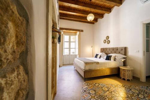 锡拉库扎Ortigia Boutique Palace的一间卧室设有一张床和一个大窗户