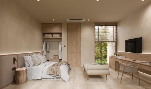 芭东海滩Eden Resort & Villas的一间卧室配有一张床、一张书桌和一台电视