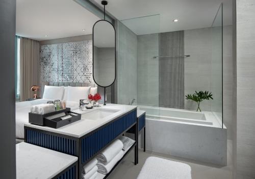 曼谷Avani Sukhumvit Bangkok Hotel的浴室配有盥洗盆和浴缸。