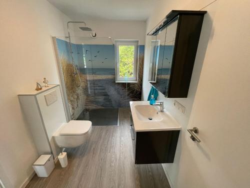 不来梅港Ferienhaus Urlaubshafen的一间带水槽、卫生间和镜子的浴室