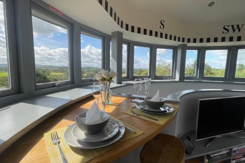 比斯特The Windmill Blackthorn Hill的用餐室配有玻璃桌和电视