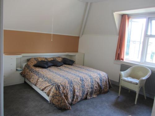Dodewaardde Flesch的卧室配有床、椅子和窗户。