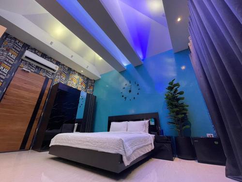 纳仲天Skeyndor Health & Resort的一间卧室设有一张床和蓝色的墙壁