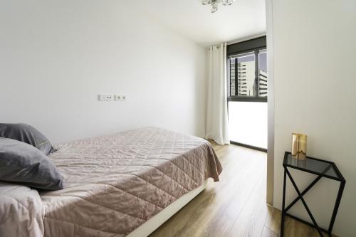 科尔内拉德罗布雷加特Sunsets and the pool in Barcelona的白色的卧室设有床和窗户