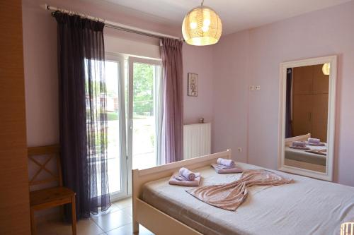 乐托卡亚Olympus Riviera Modern Luxury Villa in Leptokarya的一间卧室配有一张带镜子的床和窗户