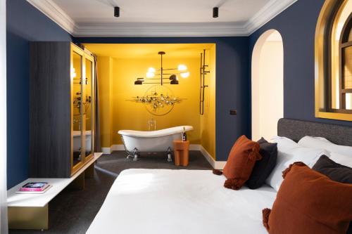 索非亚Oborishte 63,The Art Boutique Hotel by Sandglass的一间卧室设有带浴缸的浴室和一张床