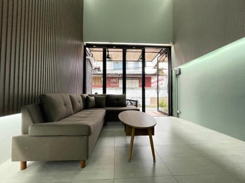 清迈Comfort Zone Hostel @ Tha Pae的客厅配有沙发和桌子