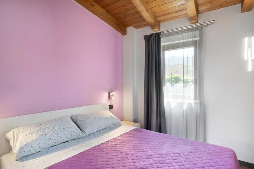 维拉诺瓦达尔本加Agriturismo il Borgo - Rosmarino的一间卧室设有紫色的床和窗户