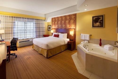 伦敦Courtyard by Marriott London的酒店客房配有一张床和浴缸。
