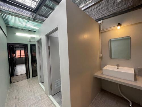清迈Comfort Zone Hostel @ Tha Pae的一间带水槽的浴室和墙上的电视