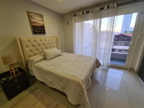 圣克鲁斯Moderno Monoambiente Amoblado en Equipetrol的一间卧室设有一张床和一个大窗户