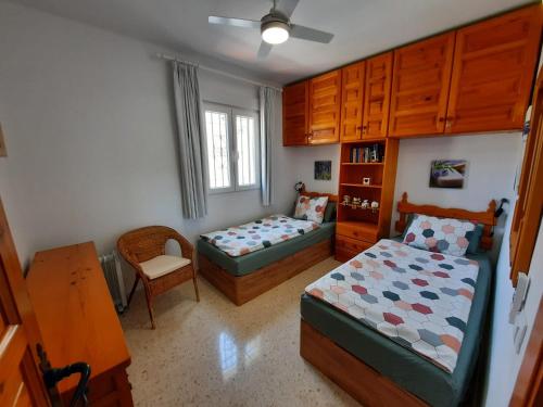 内尔哈Las Palmas 15C Oasis Properties的一间卧室配有两张床和椅子
