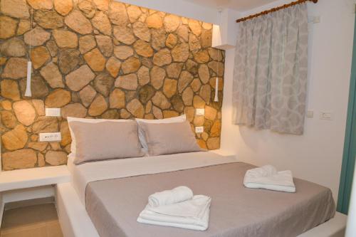特里皮蒂Mylopetra Milos Suites的一间设有床铺的房间,上面有两条毛巾