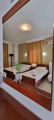 尼欧波洛伊马诺拉斯公寓式酒店的镜子反射着一间卧室,配有两张床